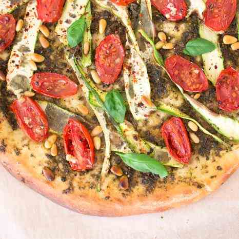 Vegan pizza with pesto, courgette and toma