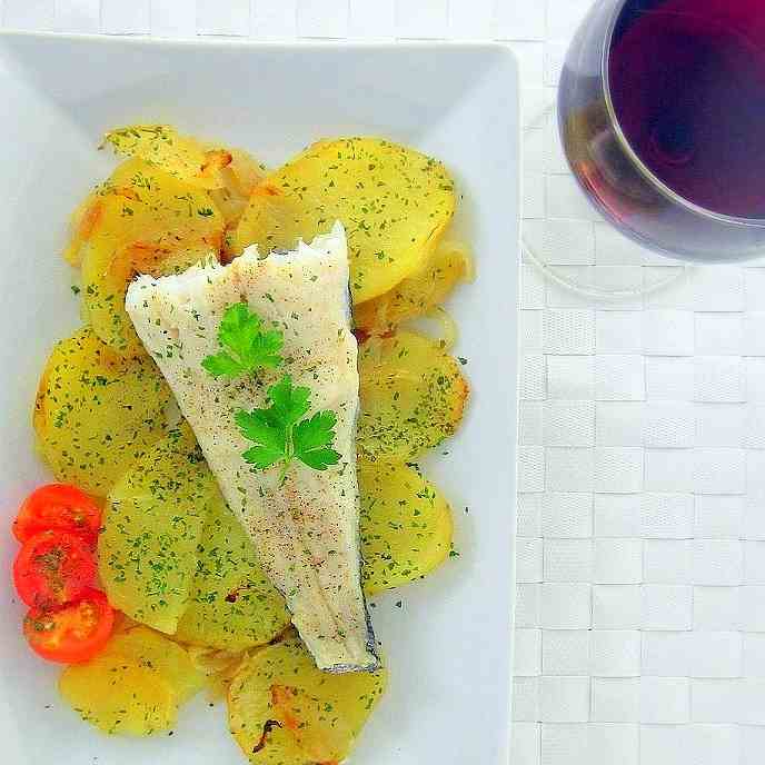 Baked hake fish fillet with potatoes 